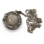 Vintage silver circular locket with relief design on a silver neck chain. P&P Group 1 (£14+VAT for
