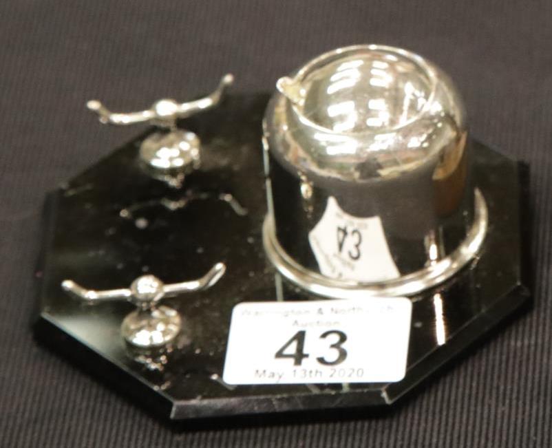 An Art Deco chromium inkwell with sprung cover and pen stand, mounted on an octagonal black glass