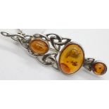 Amber three stone ornate brooch. P&P Group 1 (£14+VAT for the first lot and £1+VAT for subsequent