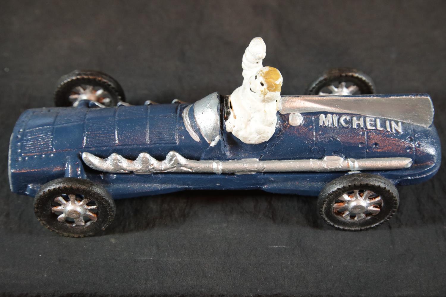 Cast iron Michelin man racing car in blue, L: 27 cm. P&P Group 2 (£18+VAT for the first lot and £2+