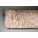 Pink ground floral design rug with fringe, W: 2.4m. Requires cleaning but no holes or tears. This