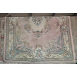 Large pink ground woolen rug with fringe, L: 2.8 m, W: 1.8 m. This lot is not available for in-house