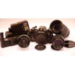 Cased Nikon film camera with accessories and lenses including a Nikon lens series E 100m 1:2.8