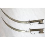 A pair of Middle Eastern sabres having brass inlaid grips. P&P Group 2 (£18+VAT for the first lot