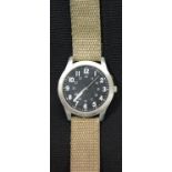 Military type black faced watch on canvas strap. P&P Group 1 (£14+VAT for the first lot and £1+VAT