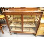 Late 19th century mahogany two door glazed display cabinet raised on claw and ball supports, 123 x