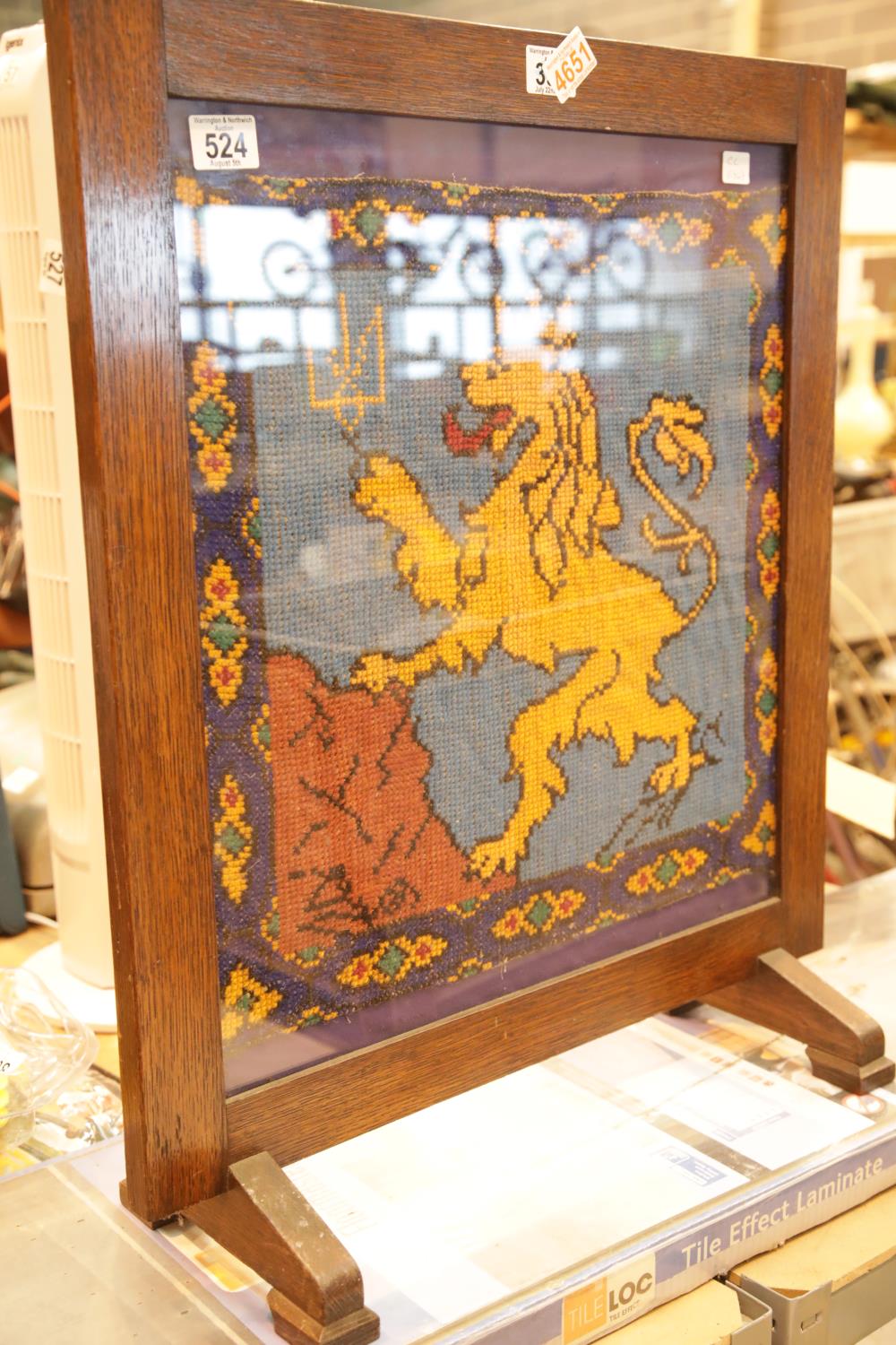 Glazed oak firescreen with woolwork crowned lion. This lot is not available for in-house P&P.