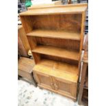 Golden oak three shelf bookcase with twin door lower cupboard, 127 x 66 x 28 cm. This lot is not