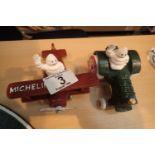 Cast iron Michelin man in plane, H: 7 cm and Michelin man in tractor, H: 8 cm. P&P Group 2 (£18+