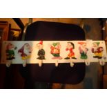 Cast iron Seven Dwarves coat hanger wall hanging, L: 58 cm. P&P Group 2 (£18+VAT for the first lot