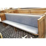 Oak church pew with centre leg and hymnal shelf to back, with upholstered seat and backrest. L: 2.65