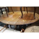 Large circular drop leaf dining table with carved edging, 120 x 180 cm extended. This lot is not