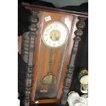 Large mahogany cased Ansonia type chiming wall clock with key and pendulum, L: 100 cm. This lot is