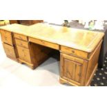 Modern pine twin pedestal desk, the tooled leather top above central drop front keyboard drawer