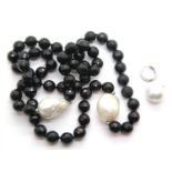 Black glass bead necklace set with two Baroque pearls and a single silver set Baroque pearl earring.