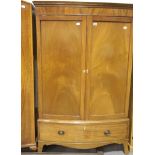 Edwardian mahogany combination wardrobe, bow fronted with two doors above a single long drawer.