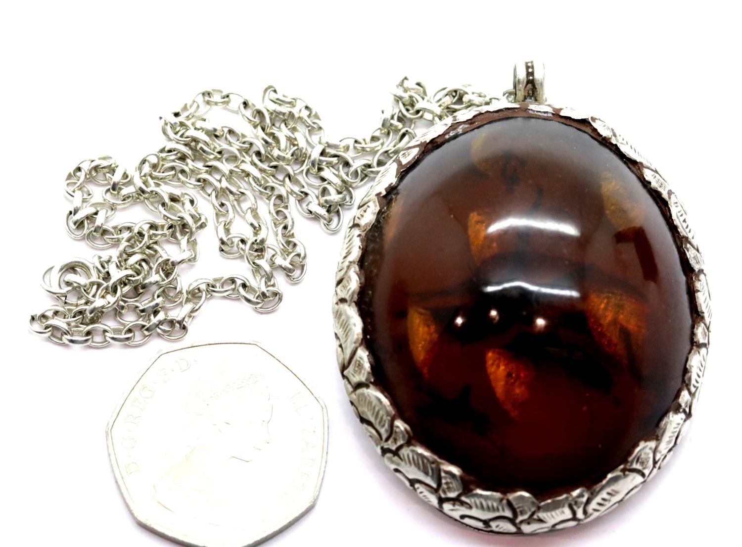 Silver and amber large pendant on a silver chain. P&P Group 1 (£14+VAT for the first lot and £1+