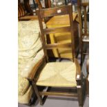19thC rush seat ladder back rocking armchair. Not available for in-house P&P.