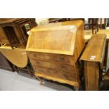 Art Deco walnut fall front bureau, the fitted interior sita above a base of three long drawers.