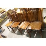 Old Charm circular extending oak dining table, with a set of four oak wheel back dining chairs.