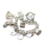Silver charm bracelet with seven charms, 60g. P&P Group 1 (£14+VAT for the first lot and £1+VAT