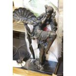Heavy metal lamp with figurine to centre with glass panel shade, H: 44 cm. Not available for in-