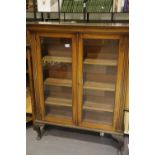 Mahogany glazed two door bookcase on cabriole feet, 27 x 100 x 127 cm H. Not available for in-