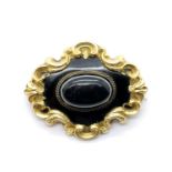 Victorian yellow metal mourning brooch with agate centre and vacant lock of hair panel to verso,