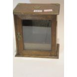 Early 20th century oak smokers cabinet with single glazed door, integral two section pipe rack and