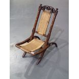 Victorian carved walnut folding picnic chair with woven canework seat and backrest. Not available