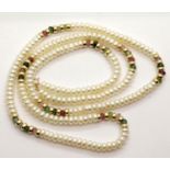 Long string of pearls set with 14ct gold rings and semi precious stones, estimated 8g of 14ct