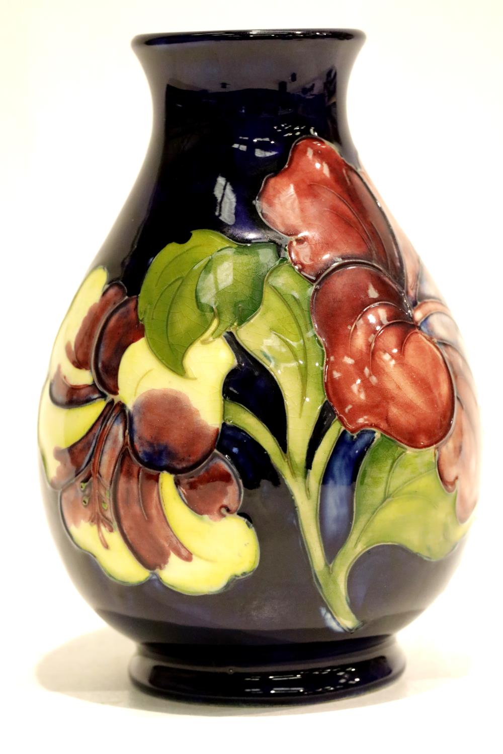 Moorcroft blue ground vase in the Hibiscus pattern. P&P Group 2 (£18+VAT for the first lot and £3+