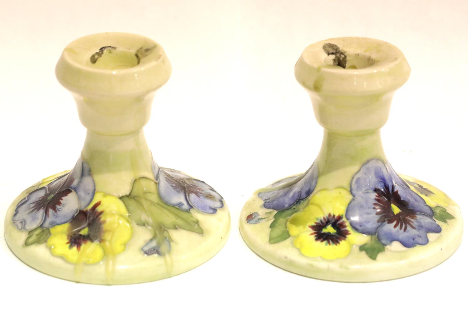 Moorcroft cream ground pair of Pansy candlesticks. P&P Group 2 (£18+VAT for the first lot and £3+VAT