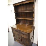 Modern oak Priory style dresser, the two shelf plate rack above a sideboard base of cupboards and