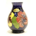 Moorcroft blue ground vase in the Hibiscus pattern. P&P Group 2 (£18+VAT for the first lot and £3+