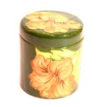 Moorcroft tube-line decorated cylindrical jar and cover in the Coral Hibiscus pattern, H: 9.5 cm.