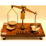 Early 20th century brass set of apothecary scales on a walnut base, steel plates and graduated