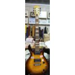 Unnamed orange/brown sunburst effect electric guitar with mother of pearl fret markers and twin