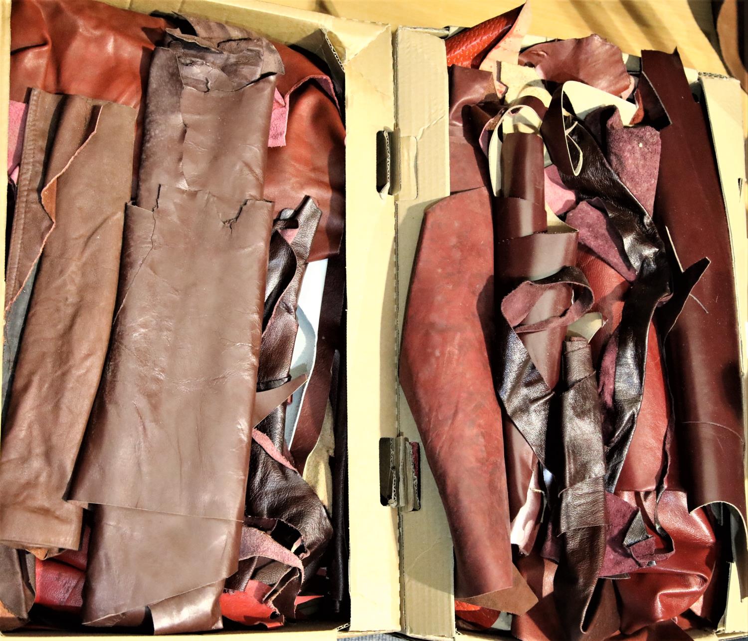 Two boxes of red leather pieces. P&P Group 3 (£25+VAT)