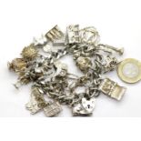 Hallmarked silver charm bracelet with 22 charms, 108g. P&P Group 1 (£14+VAT for the first lot and £