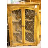 An oak two door lead glazed wall mounted corner cupboard. Not available for in-house P&P
