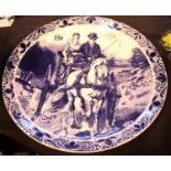 Hand painted Delftware ceramic charger plate depicting a gent and lady on horse drawn carriage.