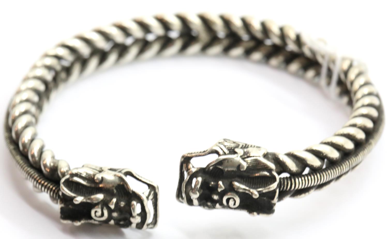 White metal Tibetan silver twisted bangle with dragon head finials. P&P Group 1 (£14+VAT for the