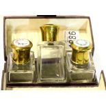 Three-bottle leather cased perfume set, each glass bottle having a guilloche enamelled presumed
