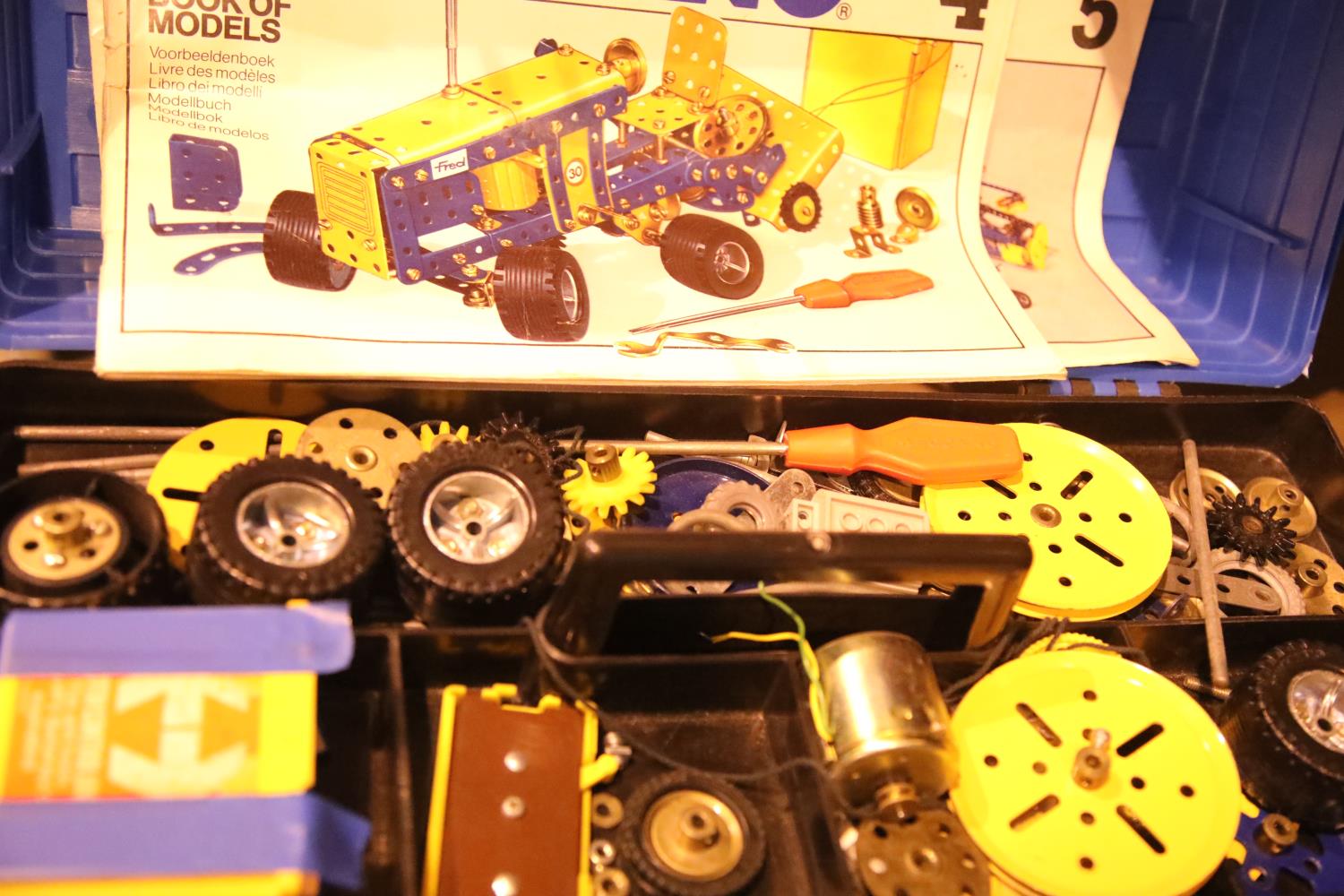 Plastic tool box of various bits of Meccano and modeling books 1, 4 and 5. Not available for in-