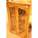 An oak two door lead glazed wall mounted corner cupboard. Not available for in-house P&P