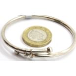 Presumed silver crossover bangle, size N, unmarked. P&P Group 1 (£14+VAT for the first lot and £1+
