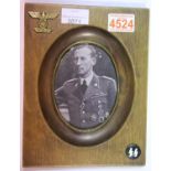 Period mahogany photograph frame with affixed brass eagle and swastika badge upper left and