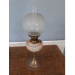 A brass and pink glass oil lamp with frosted glass shade