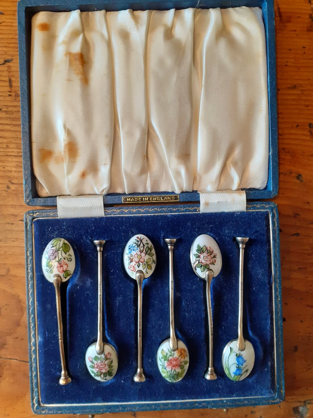 A boxed set of silver gilt coffee spoons with different enamelled flowers to the bowl Birmingham 1